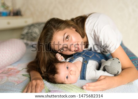 Similar – Newborn baby girl sleeping lying on blanket with her mother