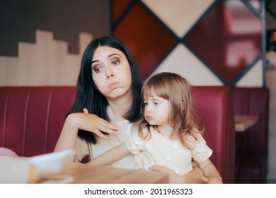 Mom and Child Feeling the Heat Sitting in Indoors Restaurant. Mother and daughter waiting in fast food booth complaining of hot weather and broken air conditioner
