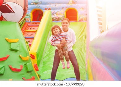 Mom And Child Jumping In An Inflatable Castle