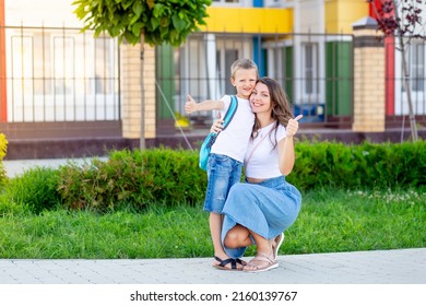 Mom With A Child With A Son With A Backpack At School Or Kindergarten Show The Class, The Concept Is Back To School