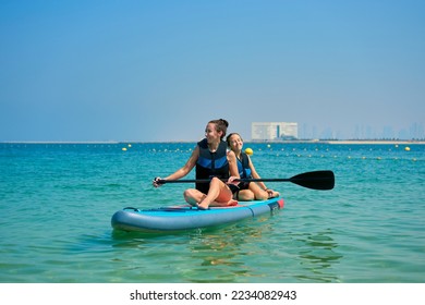 mom and child swim on a board - Powered by Shutterstock