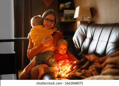 Mom And Children Hugging Together On The Couch. Mom Hugs And Comforts The Siblings. Jealousy And Sibling Relationships Dark Style