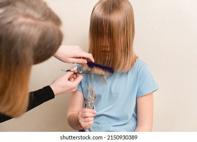 Mom Cuts Her Daughter's Wet Hair. Cutting Hair At Home. Life Hacks And Rules Of Hair Care. Special Combs And Scissors For Hairdressers.