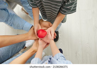 Mom, Dad And Children All Together Holding A Little Red Heart In Their Hands. Top View Close Up, High Angle Closeup Shot. Family, Love, Care, Health, Life, Help, Charity, Human Organ Donation Concepts