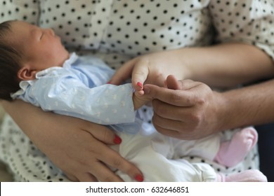 Mom And Dad Are Holding The Baby