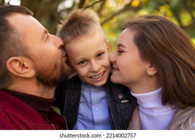 Mom And Dad Kissing A Child Boy Between Themselves, Close-up Portrait