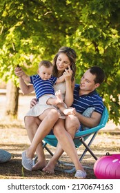 Mom Dad And Little Boy Play In An Inflatable Pool Near A Sun Lounger On The Lawn