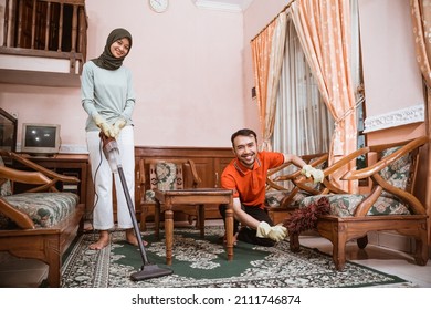 Mom And Dad Smile While Cleaning The Family Room