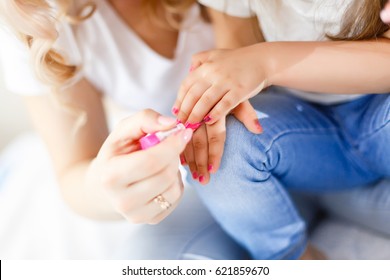 Mom And Daughter In The Bedroom On The Bed In The Curlers Make Up, Paint Their Nails And Have Fun Mom Paints Nails To My Daughter On The Bed