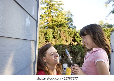 Mom And Daughter Being Silly With Paint On Their Faces. Horizontally Framed Photograph