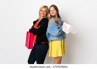 Mom And Daughter Buying Some Clothes Isolated On White Background Looking Over The Shoulder With A Smile