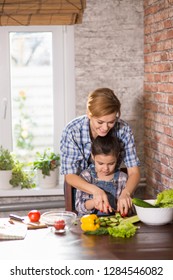 Mom And Daughter Cook Together At Home, Woman And Girl Prepare Salad In The Kitchen