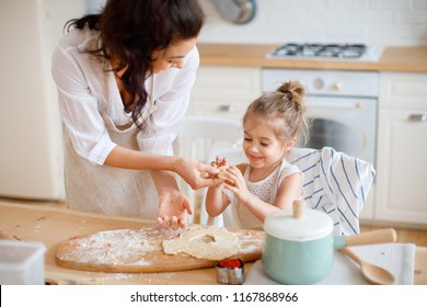 Mom and daughter are cooking in the kitchen of a country house