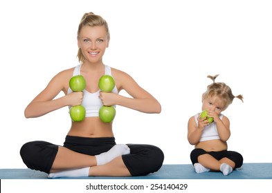 Mom and daughter engage in fitness dumbbells of green apples