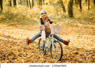 Mom and daughter have fun on the same bike. Autumn photo shoot. - Powered by Shutterstock