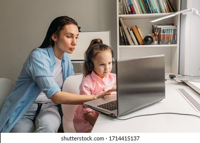 Mom And Daughter Are At Home Today. They Work Remotely On A Laptop. Mom Helps Her Daughter Complete Tasks On A Computer.