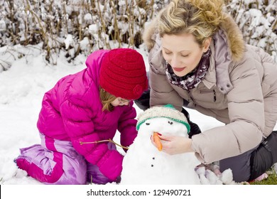 Mom And Daughter Make A Snowman.best Fokus On The Hair Of Mother