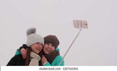 Mom With Daughter, Photograph Selfie On Phone, Winter Snow Park. They Laugh, Smile And Take Pictures.