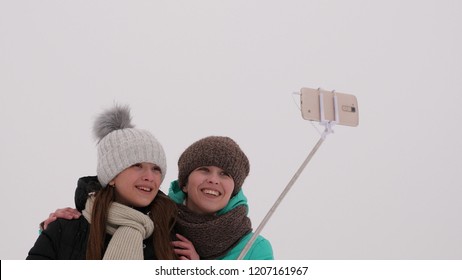 Mom With Daughter, Photograph Selfie On Phone, Winter Snow Park. They Laugh, Smile And Take Pictures.