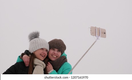 Mom With Daughter, Photograph Selfie On Phone, Winter Snow Park. They Laugh, Smile And Take Pictures.