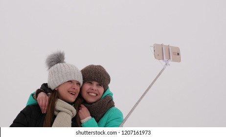 Mom With Daughter, Photograph Selfie On Phone, Winter Snow Park. They Laugh, Smile And Take Pictures.