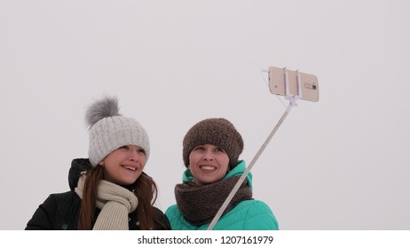 Mom With Daughter, Photograph Selfie On Phone, Winter Snow Park. They Laugh, Smile And Take Pictures.