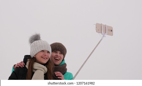 Mom With Daughter, Photograph Selfie On Phone, Winter Snow Park. They Laugh, Smile And Take Pictures.