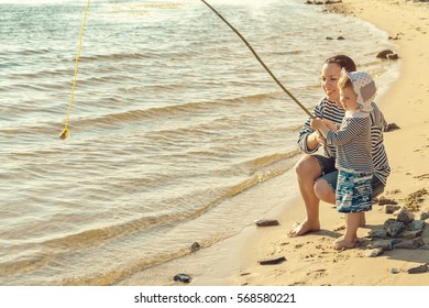 Mom And Daughter Playing On The Beach. They Catch Fish.