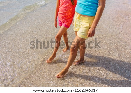 Mom and daughter running on the beach . Family moments, having fun and enjoying summer holiday