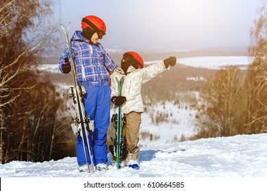 Mom And Daughter, In Ski Equipment Play With Snow In The Ski Resort