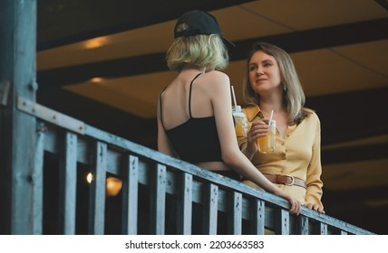 Mom And Daughter Are Talking Outdoors.