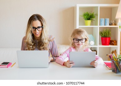 Mom and daughter using modern tech together - Shutterstock ID 1070117744