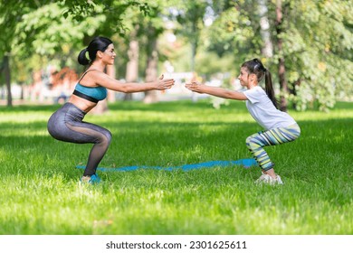 Mom and daughter working out together in city park. - Powered by Shutterstock