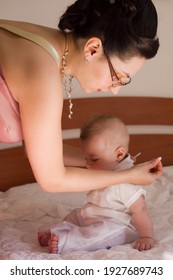 Mom Dressing Baby On Baptism Day