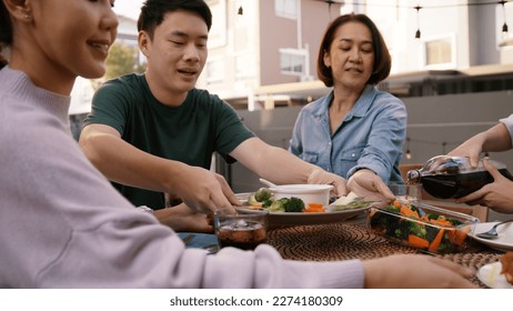 Mom enjoy cooking for family day dining at dine table cozy patio front yard home. Mum passing food serving drink to group four asia people young adult man woman friend fun joy relax warm picnic eating - Powered by Shutterstock