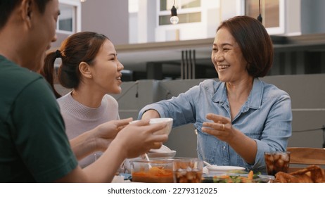 Mom enjoy thai meal cooking for family day home dining at dine table cozy patio. Mum passing serving food to group four asia people young adult man woman friend fun joy relax warm night picnic eating. - Powered by Shutterstock