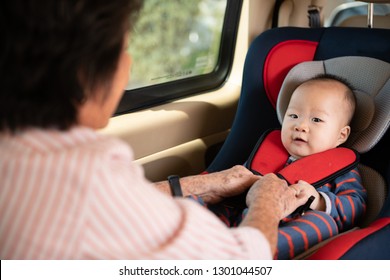 Mom Fasten His Little Baby In The Car Seat. Asian People In Car.