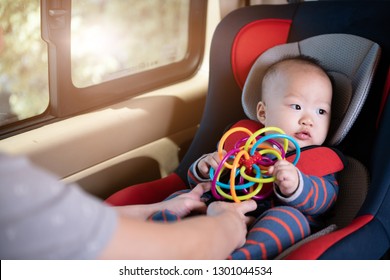 Mom Fasten His Little Baby In The Car Seat. Asian People In Car.