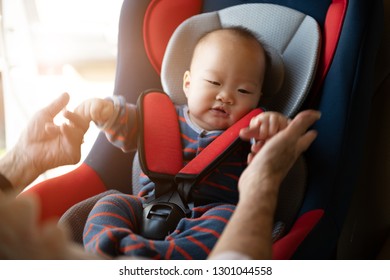 Mom Fasten His Little Baby In The Car Seat. Asian People In Car.