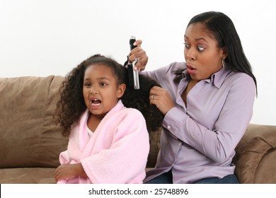 Mom finds a tangle brushing daughters hair on the couch. - Powered by Shutterstock