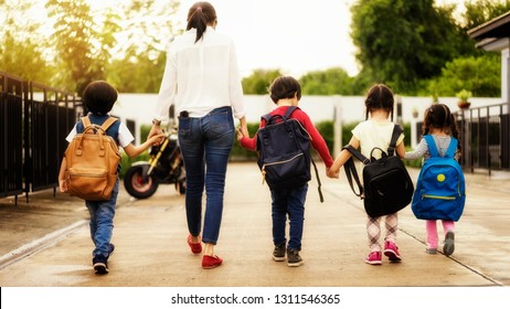 Mom And Four Kindergarten Kids Holding Hand Carry Schoolbag Walking To School Bus.preschool Concept.first Day Of Semester