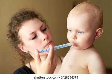 Mom Gives Her Little Child Medicine Through A Syringe