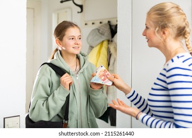 Mom Gives Pocket Money To Daughter In The Hallway Of The Apartment