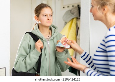 Mom Gives Pocket Money To Daughter In The Hallway Of The Apartment