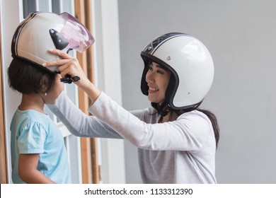 Mom Help Her Daughter To Wear A Helmet Before Riding A Motor Bike