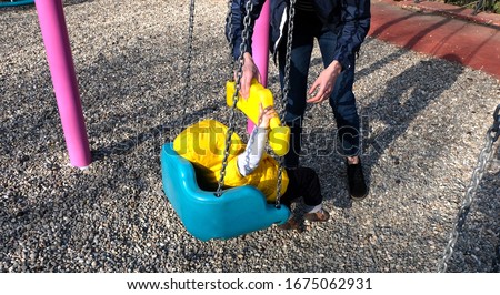 Mom helping her baby boy getting off the swing Stok fotoğraf © 