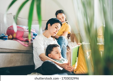 Mom Helping Kids With Homework. Girl Playing The Flute On Sofa.