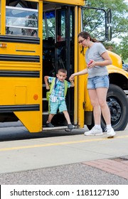 Mom Helping Small Son Off A School Bus