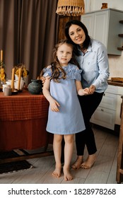 Mom And Her Daughter In A Blue Dress In The Kitchen Are Going To Cook Dinner. Healthy Eating Concept. Childhood Carefree.