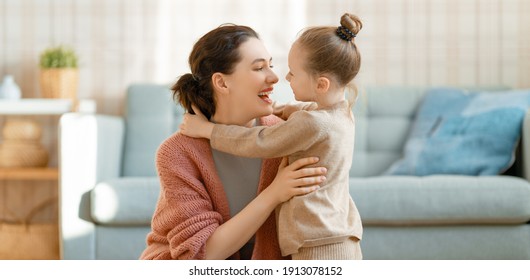 Mom And Her Daughter Child Girl Are Playing, Smiling And Hugging At Home. 